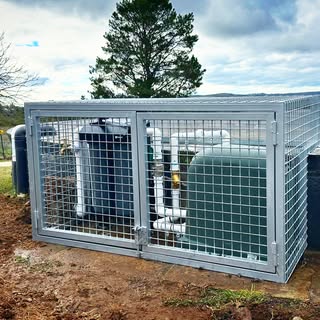 Galvanised mesh equipment enclosure around pumps and tanks